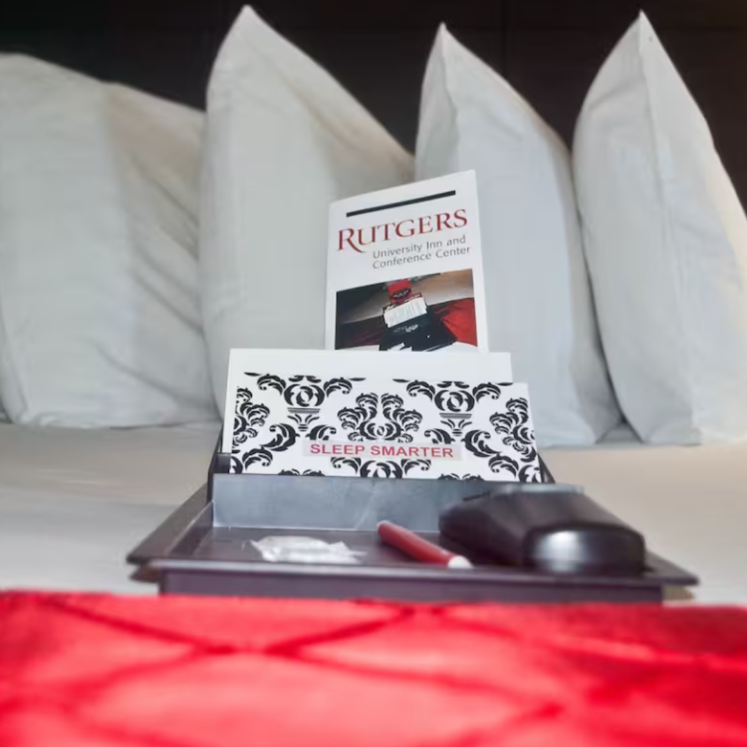 close up image of a bed with pillows, a welcome note, and a packet of information about the inn