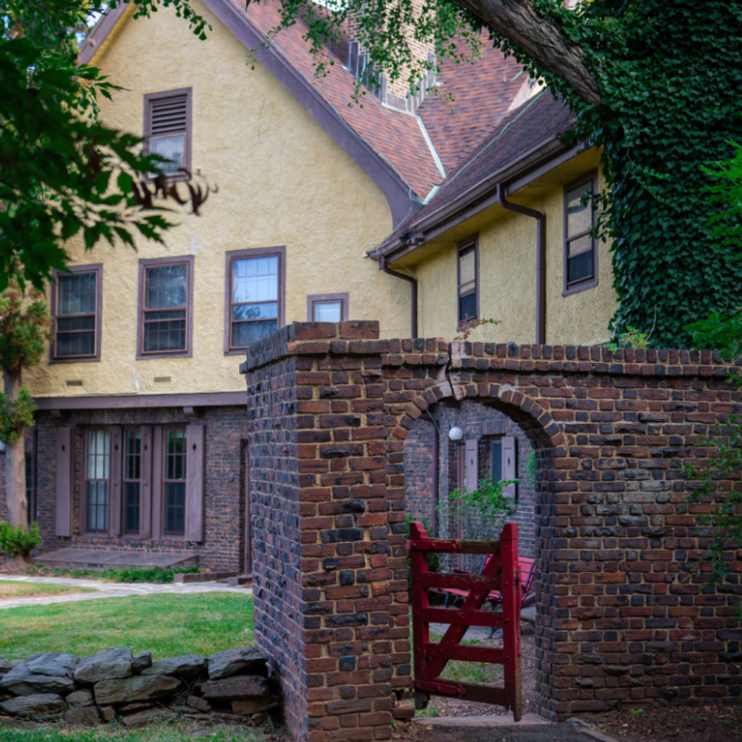 outdoor image of the inn with it's original red gate with brick archway and red door